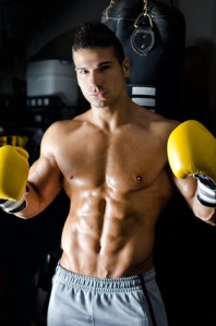 Handsome shirtless young man with boxer's gloves